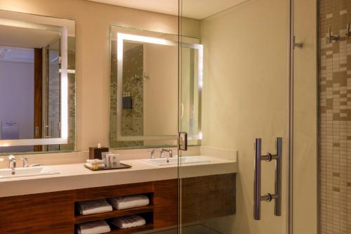 a bathroom with two sinks and a glass shower at The Westin Cozumel in Cozumel