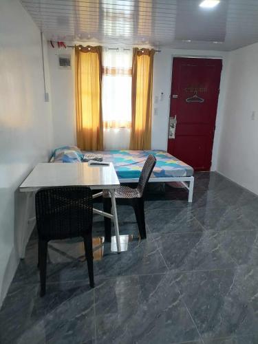 a room with a table and chairs and a bed at FJM Transient in Tarlac