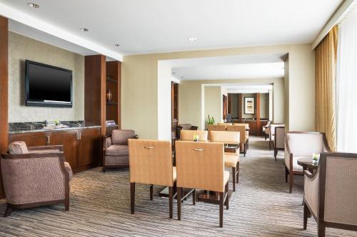 a waiting room with tables and chairs and a television at The Westin Book Cadillac Detroit in Detroit