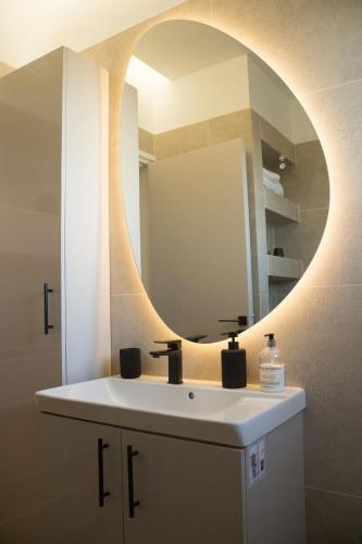 a bathroom with a sink and a mirror at Delightful 1st Floor Xanthippis Apartment in Strovolos