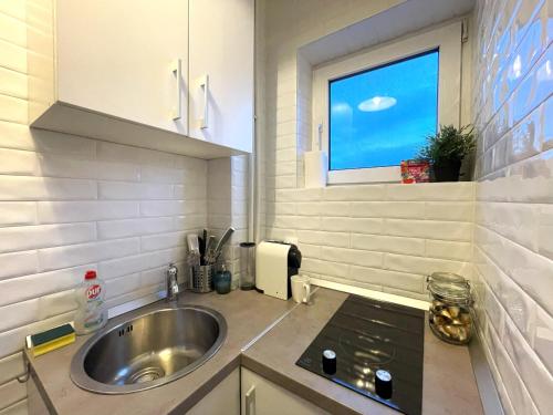 a small kitchen with a sink and a window at Rooftop Studio In the heart of Bucharest w Netflix in Bucharest