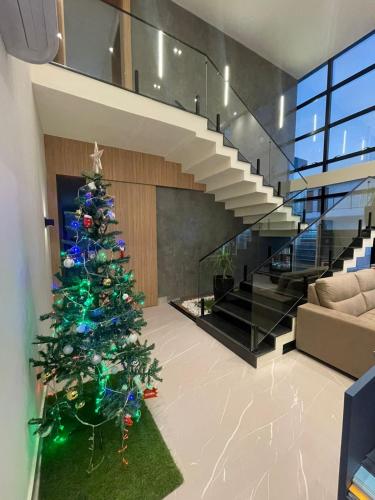 a christmas tree in a living room with a staircase at Luster Hotel in João Câmara