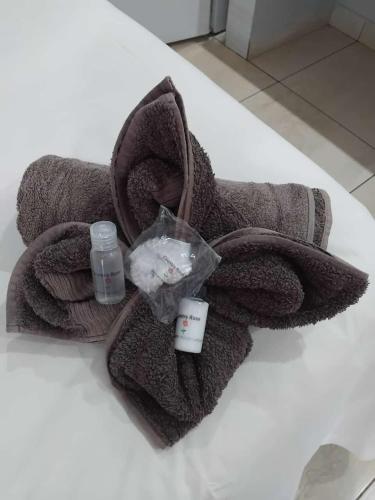 a towel with a bottle of soap and a bottle of water at Country Rose in Hluhluwe