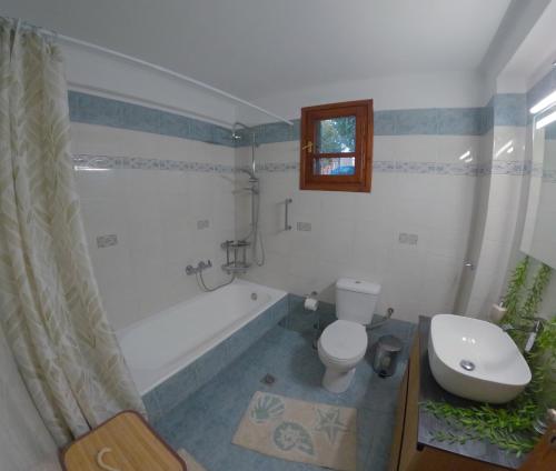 a bathroom with a tub and a toilet and a sink at Almond's Room in Mirina