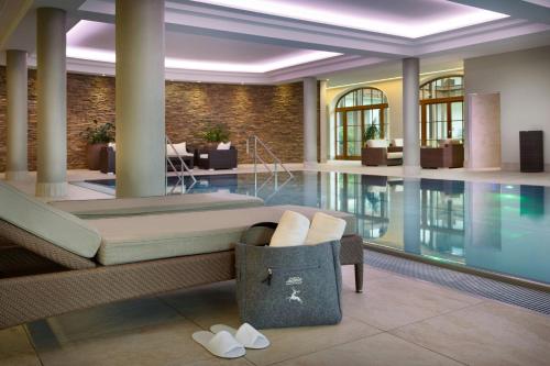 a hotel lobby with a pool and a bed at Arabella Jagdhof Resort am Fuschlsee, a Tribute Portfolio Hotel in Hof bei Salzburg