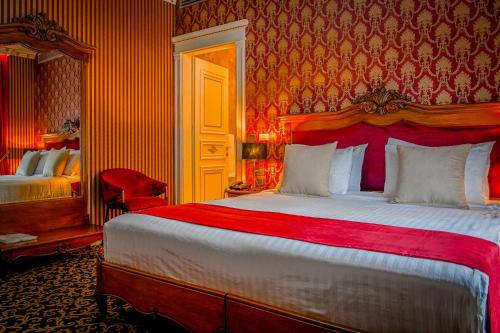 a bedroom with a large bed with a red headboard at Envy Hotel in Durrës