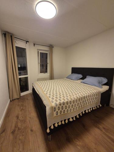 a bedroom with a bed and two windows at Moderne 2 Roms Leilighet i Hjertet av Oslo in Oslo