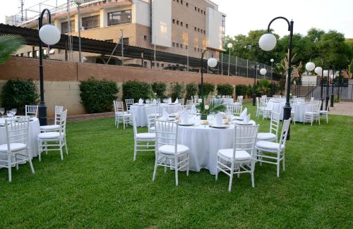 a group of tables and chairs with white table cloth at Hotel San Pablo Sevilla in Seville