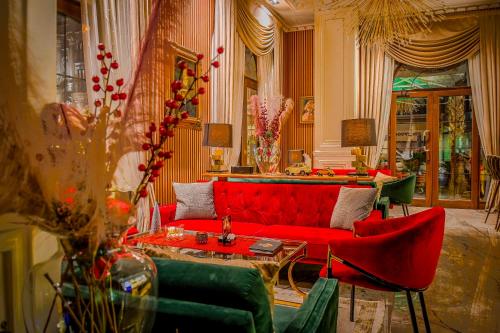 a living room with a red couch and chairs at Envy Hotel in Durrës