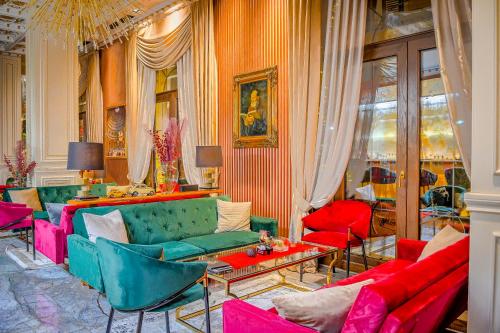 a living room with red and green couches at Envy Hotel in Durrës