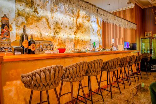 a bar with a row of stools in a room at Envy Hotel in Durrës