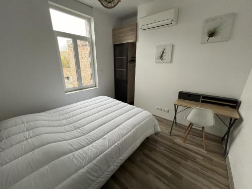 une chambre avec un lit, un bureau et une fenêtre dans l'établissement Amiens, appart douillet 2-4P, à Amiens
