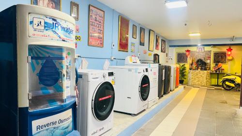 a laundry room with washing machines in a store at Pa Chalermchai Guesthouse in Bangkok