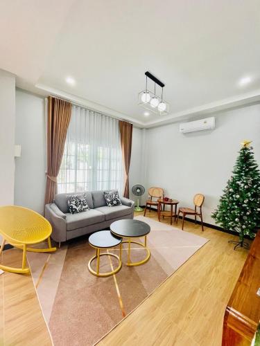 a living room with a couch and a christmas tree at Fiw And Fair Pool Villa Hatyai in Hat Yai Intl