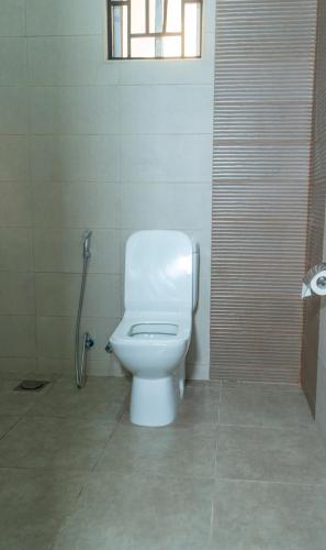 a white toilet in a bathroom with a window at Nguchiro Palace in Moshi