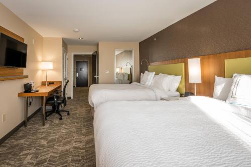 a hotel room with two beds and a desk at SpringHill Suites by Marriott Denton in Denton