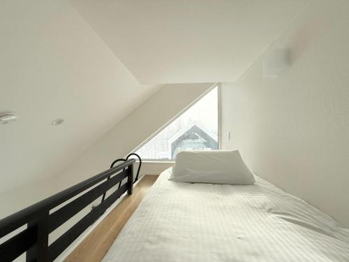 a white bedroom with a bed and a window at Niseko White Villa II Annupuri in Niseko