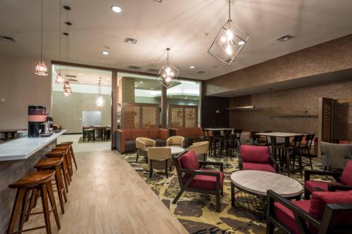 a restaurant with tables and chairs and a bar at SpringHill Suites by Marriott Denton in Denton