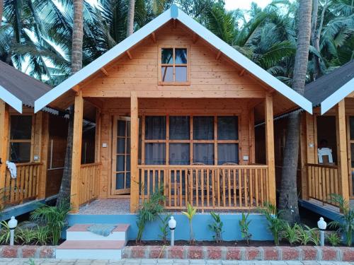 a cottage on the beach with palm trees at Sand Tent Beach Resort Patnem in Patnem