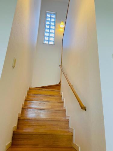 a staircase with wooden floors and a window at Ocean Terrace金武 in Kin