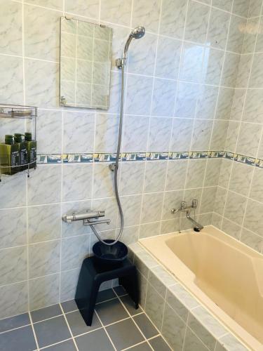 a bathroom with a toilet and a bath tub at Ocean Terrace金武 in Kin