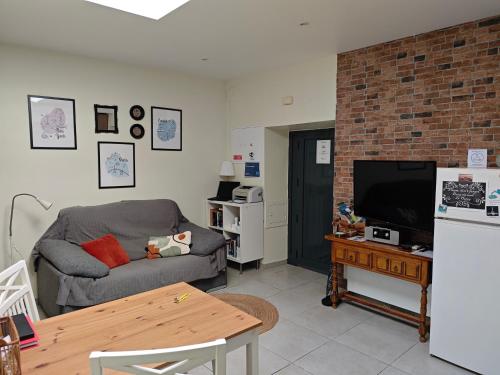 a living room with a couch and a television at The Sunny Cottage by Freetimealgarve in Faro