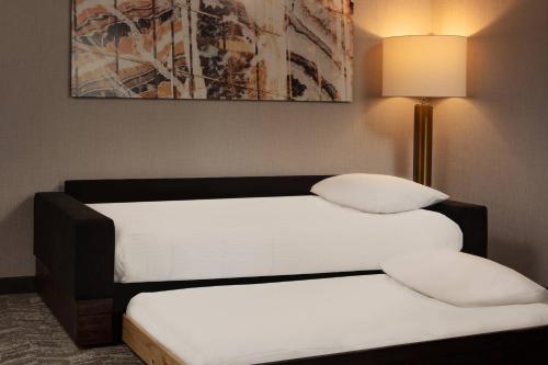 two beds in a room next to a lamp at SpringHill Suites by Marriott Ames in Ames