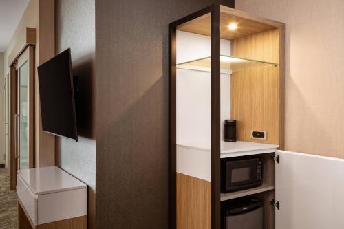 a small room with a microwave and a kitchen at SpringHill Suites by Marriott Ames in Ames