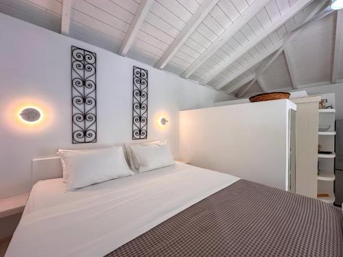 a white bedroom with a bed and a white ceiling at Panta'kei in Stavros