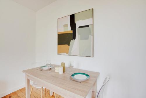 une table à manger avec un tableau mural dans l'établissement Hypercentre Vincennes au pied du métro, à Vincennes