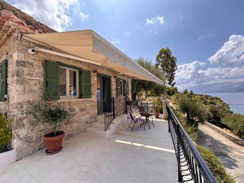 a house with a balcony with a view of the water at Panta'kei in Stavros