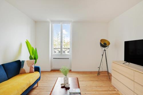 un salon avec un canapé et une télévision dans l'établissement Hypercentre Vincennes au pied du métro, à Vincennes