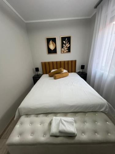 a bedroom with a large white bed with a wooden headboard at Komarom Luxe Apartment in Komárom