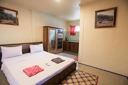 a bedroom with a bed with two towels on it at Komodo Shores Homestay in Labuan Bajo