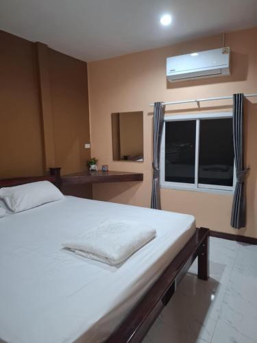 a bedroom with a white bed and a window at Patcharin house 1 in Ko Lanta Yai