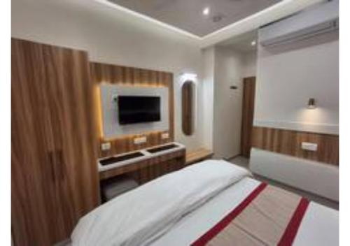 a bedroom with a bed and a tv on a wall at Raghav Vilas - Essence of Kashi in Varanasi