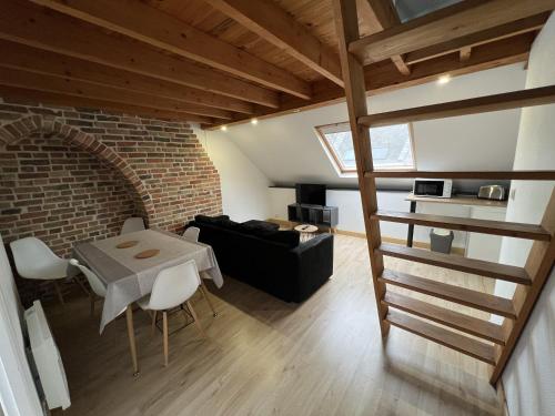 - un salon avec une table et un mur en briques dans l'établissement Amiens, sous les toits 4-6 pers, à Amiens