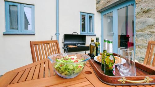 a table with a bowl of salad and bottles of beer at Buttercup in Llanrhyddlad