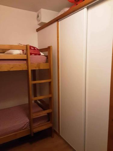 - une chambre avec des lits superposés et un placard dans l'établissement Chalet des loulous, à Narreyroux