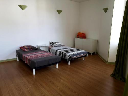 deux lits dans une chambre avec parquet dans l'établissement Maison avec 4 chambres, à Dampierre-sur-Boutonne