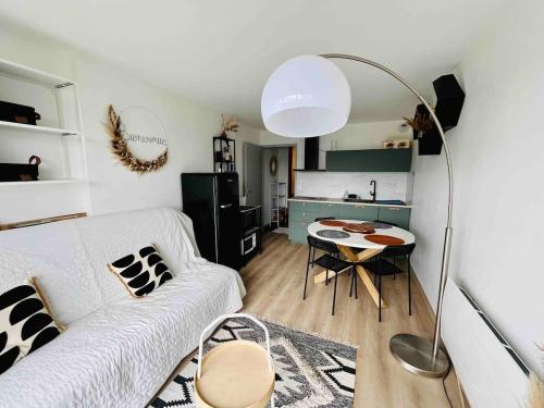 un salon avec un canapé blanc et une table dans l'établissement Appartement chaleureux avec vue Lac Matemale, aux Angles