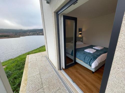 a room with a bed and a view of the water at Casa do Ferreiro T2 in Montalegre