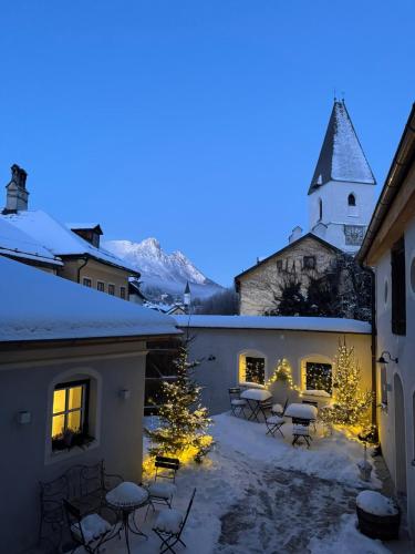 a courtyard with christmas trees and a church at Podenhaus in Bad Aussee