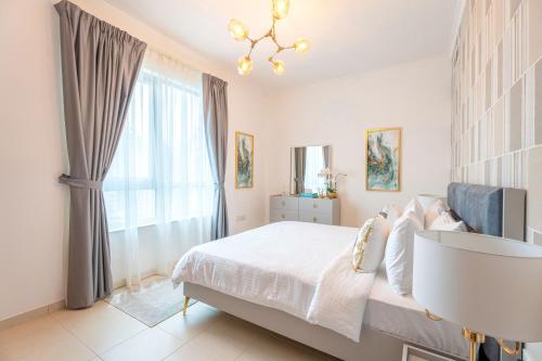a bedroom with a white bed and a window at INA Homes-Residences Tower 7 Full Burj Khalifa & Fountain Views in Dubai