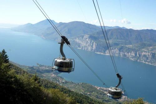 two gondolas on a ski lift over a lake at Hotel Dolomiti in Malcesine