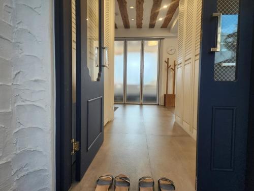 a hallway with a blue door and a pair of sandals at Palm Tree Villa in Seogwipo