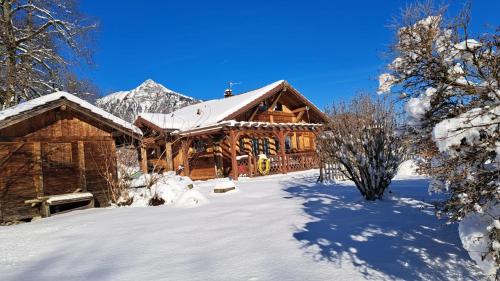 a log cabin in the snow with a mountain at Chalet Cosy avec terrasse plein sud, 2 chambres, au cœur de la Haute-Savoie in Châtillon-sur-Cluses