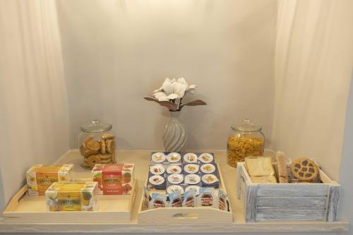 a table with boxes of food and a vase with flowers at Il Pendio B&B in Bisceglie