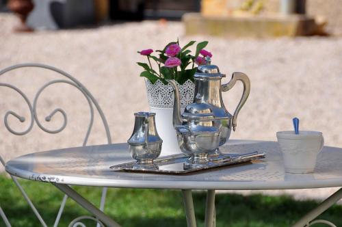 a table with a tea pot and flowers on it at Château De Matel in Roanne