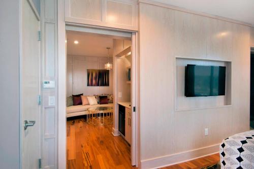 a living room with a television and a couch at SpringHill Suites by Marriott Wilmington Wrightsville Beach in Wilmington